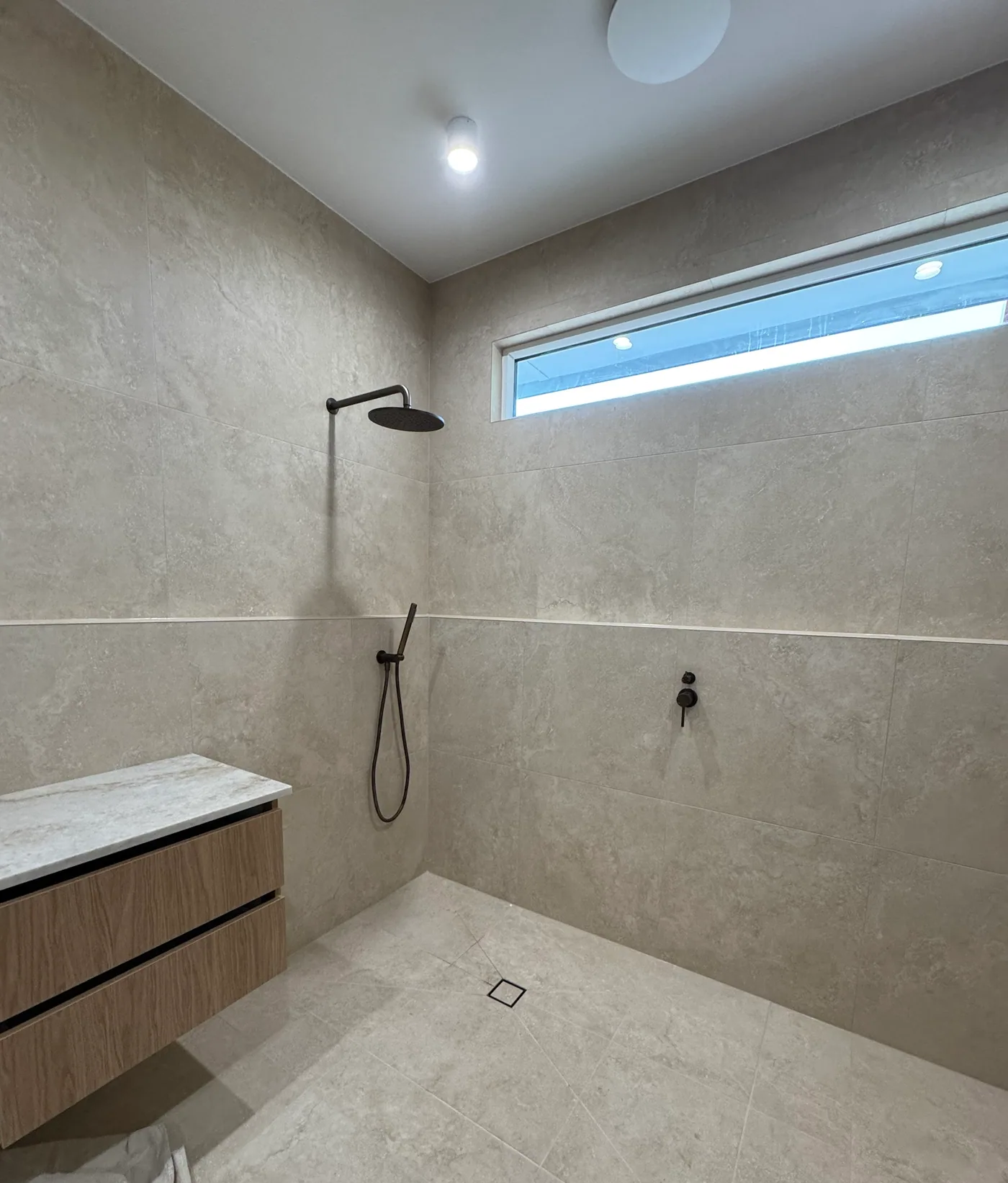 Open walk-in shower with matte black tapware fitted off by Quick2Fix